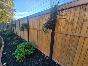 Wood fence built by Black Post Construction with landscaping and plants along the base