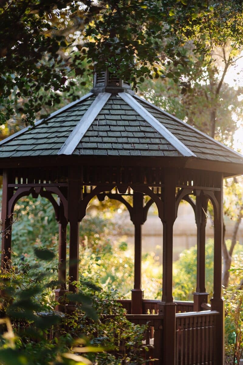 a gazebo in a park surrounded by trees